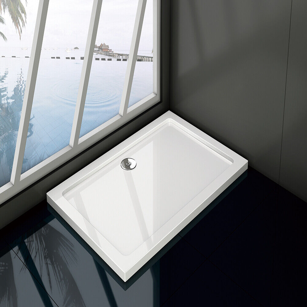 Slimline square rectangle stone shower tray in a bathroom setting, predominantly white in color with a visible waste hole position.